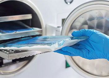 Hand in blue glove taking out sterile object